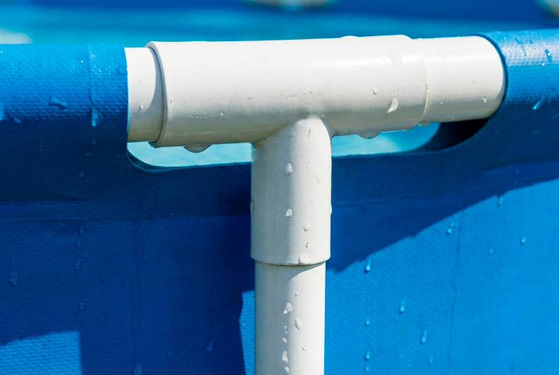 Крупний план з'єднання оцинкованих сталевих труб каркасу круглого басейну Intex Prism Frame з міцною тришаровою чашею ПВХ що демонструє якісну конструкцію надійне кріплення елементів та довговічність збірного резервуару